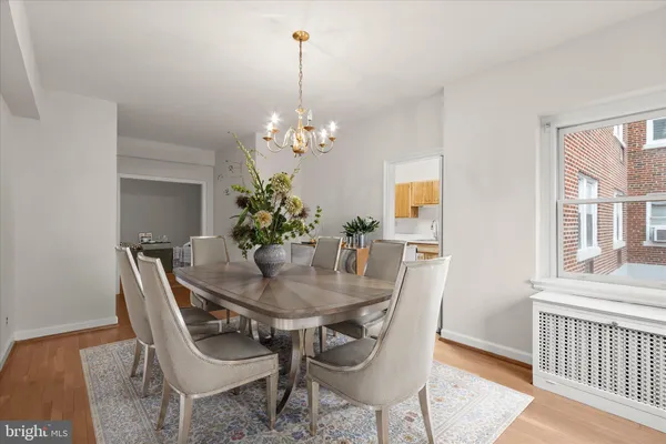 a dining room with furniture a chandelier and wooden floor