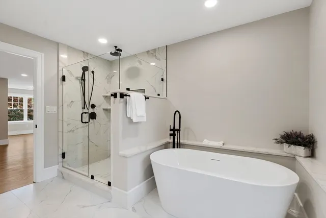 a white bath tub sitting next to a shower
