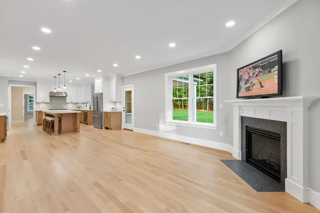a view of an empty room with a fireplace and window