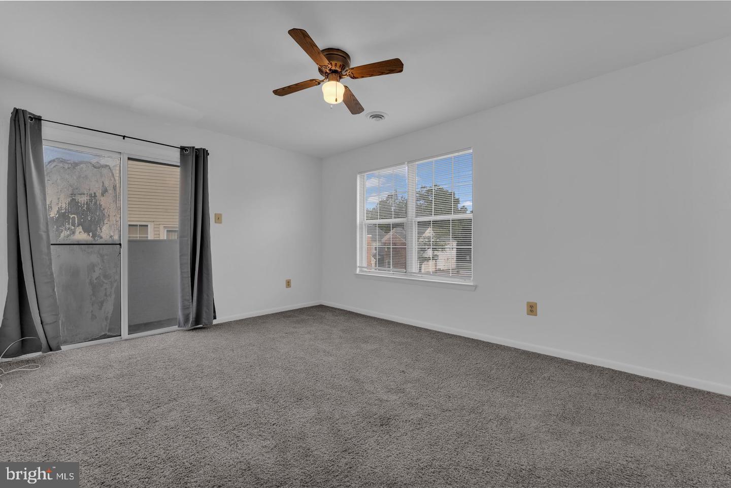 14314 Colonel Clagett Court, Unit 319 Upper Marlboro, MD 20772 - Photo 11 of 15 an empty room with windows and ceiling fan
