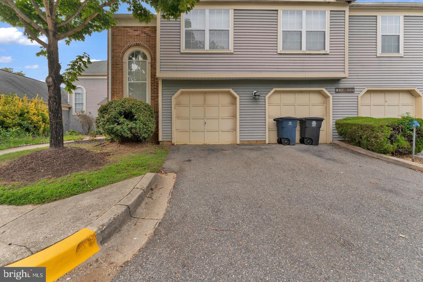 14314 Colonel Clagett Court, Unit 319 Upper Marlboro, MD 20772 - Photo 15 of 15 a front view of a house with a garden and garage