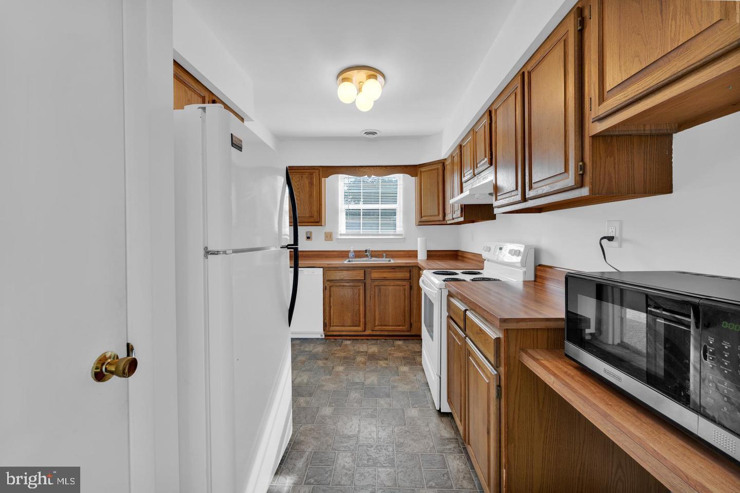 14314 Colonel Clagett Court, Unit 319 Upper Marlboro, MD 20772 - Photo 6 of 15 a kitchen with stainless steel appliances granite countertop a stove and a sink