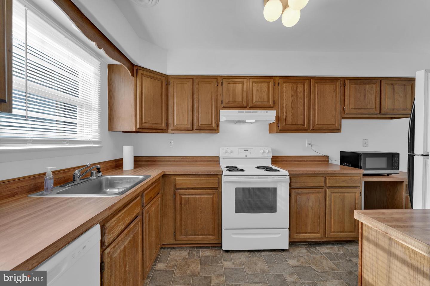 14314 Colonel Clagett Court, Unit 319 Upper Marlboro, MD 20772 - Photo 7 of 15 a kitchen with a stove sink and cabinets