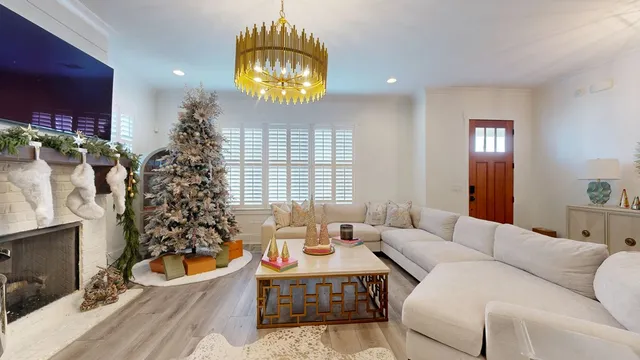 a living room with furniture a chandelier and a rug