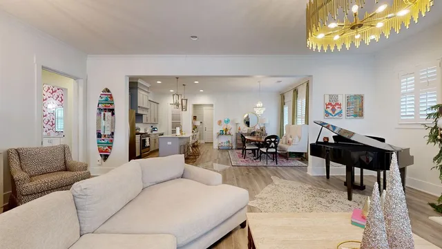 a living room with furniture a chandelier and a dining table