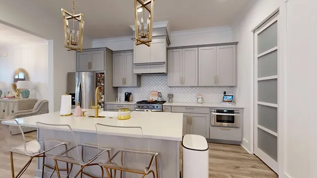 a kitchen with stainless steel appliances granite countertop a sink a stove a refrigerator and white cabinets with wooden floor