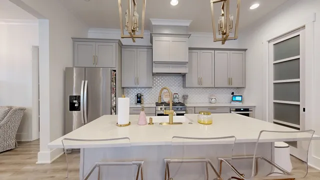 a kitchen with stainless steel appliances kitchen island granite countertop a dining table chairs and a refrigerator