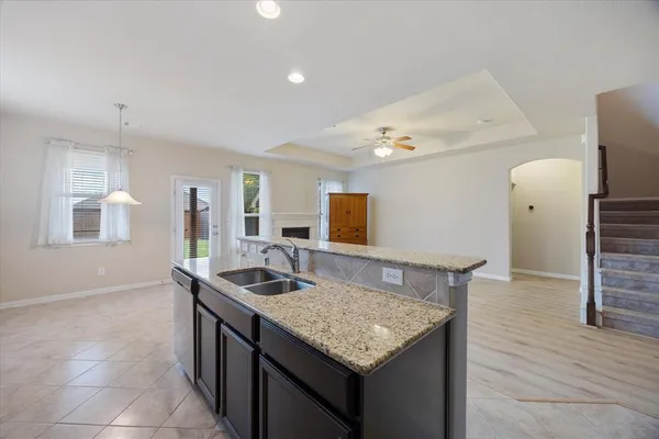 a kitchen with granite countertop kitchen island stainless steel appliances a sink stove and refrigerator