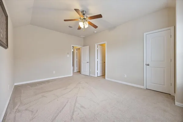 an empty room with closet and a ceiling fan