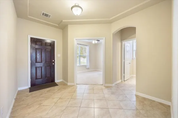 a view of a hallway with wooden floor and a bathroom