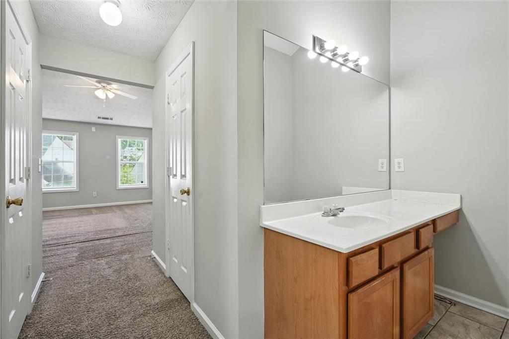 5487 Walnut Lane Lithonia, GA 30038 - Photo 22 of 43 a bathroom with a sink a mirror and a vanity