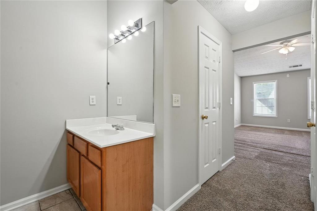 5487 Walnut Lane Lithonia, GA 30038 - Photo 23 of 43 a bathroom with a sink a mirror and a shower