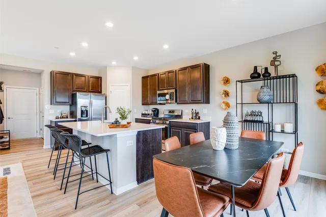 a dining table with chairs and view of kitchen