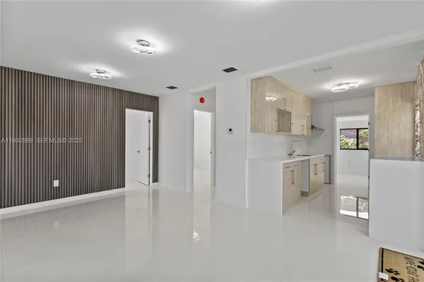 a view of a kitchen with refrigerator and white cabinets