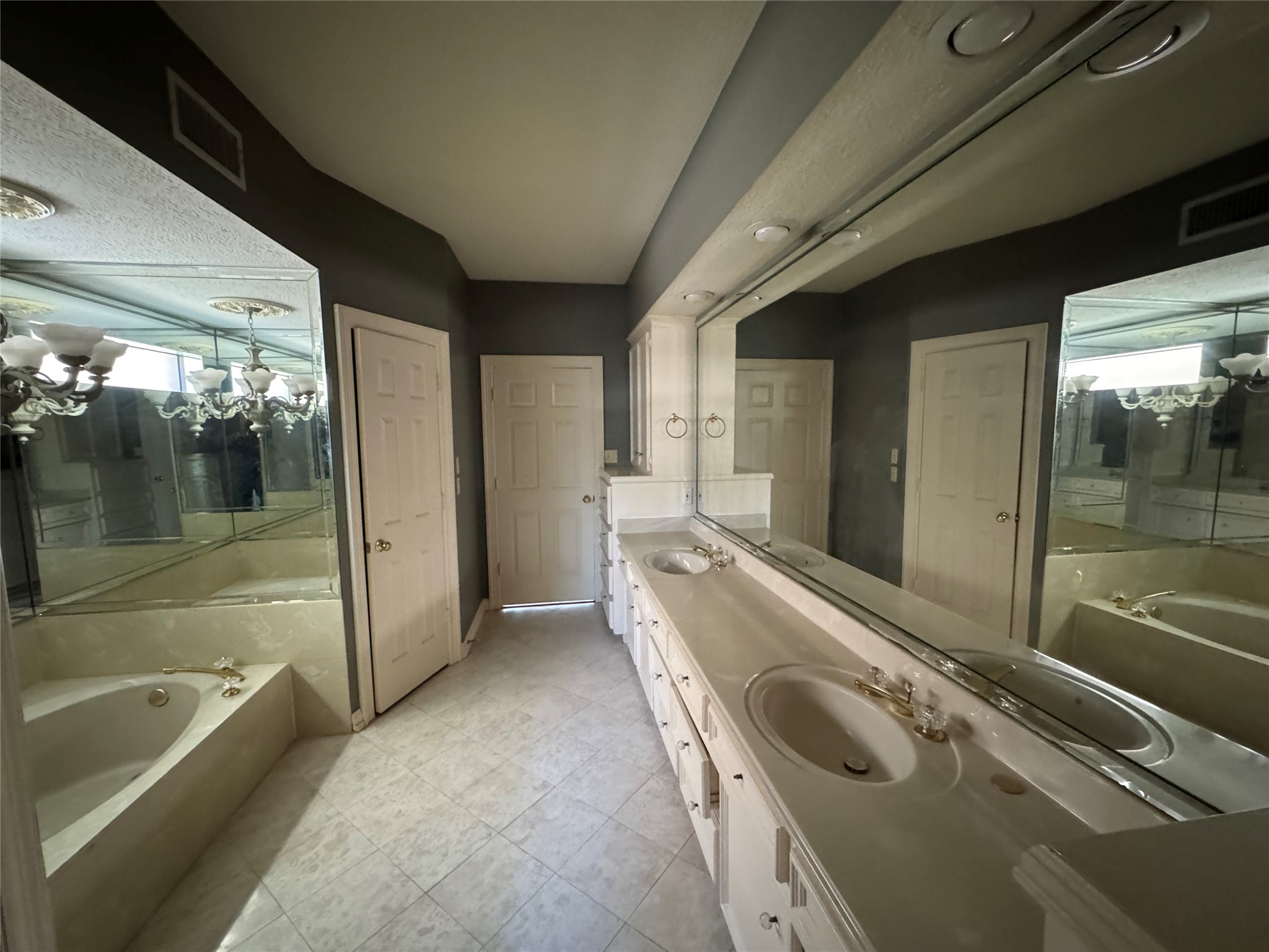 5223 Charnwick Court Houston, TX 77069 - Photo 18 of 28 a bathroom with a tub a sink and a large mirror