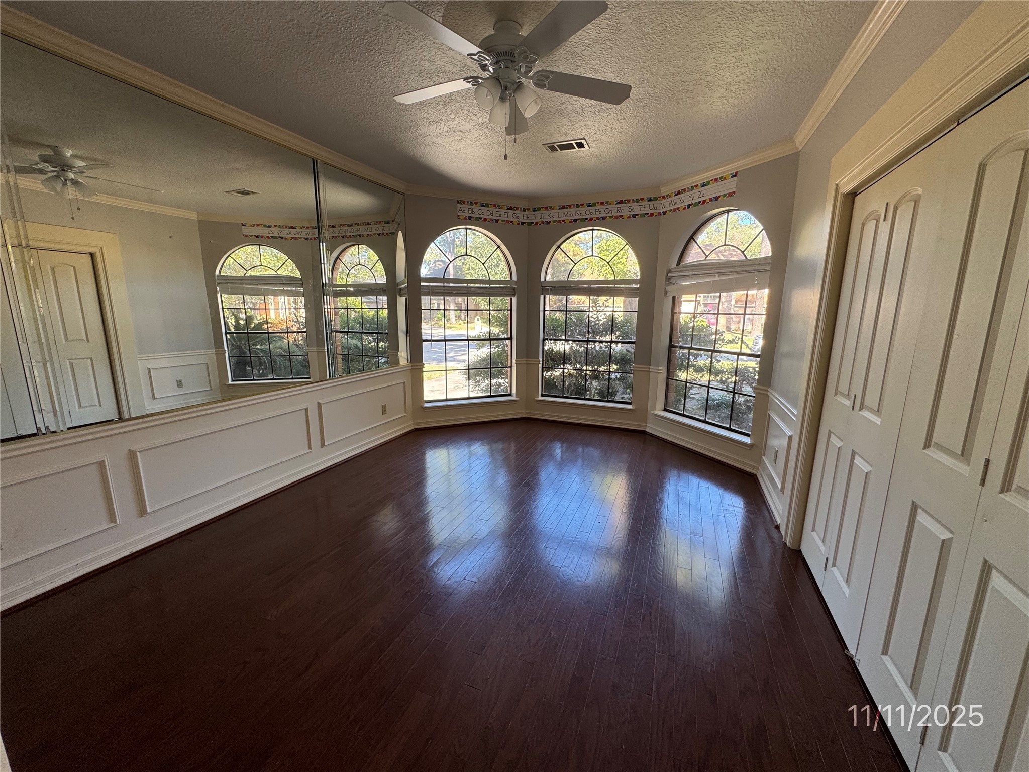 5223 Charnwick Court Houston, TX 77069 - Photo 6 of 28 an empty room with wooden floor fan and a floor to ceiling window