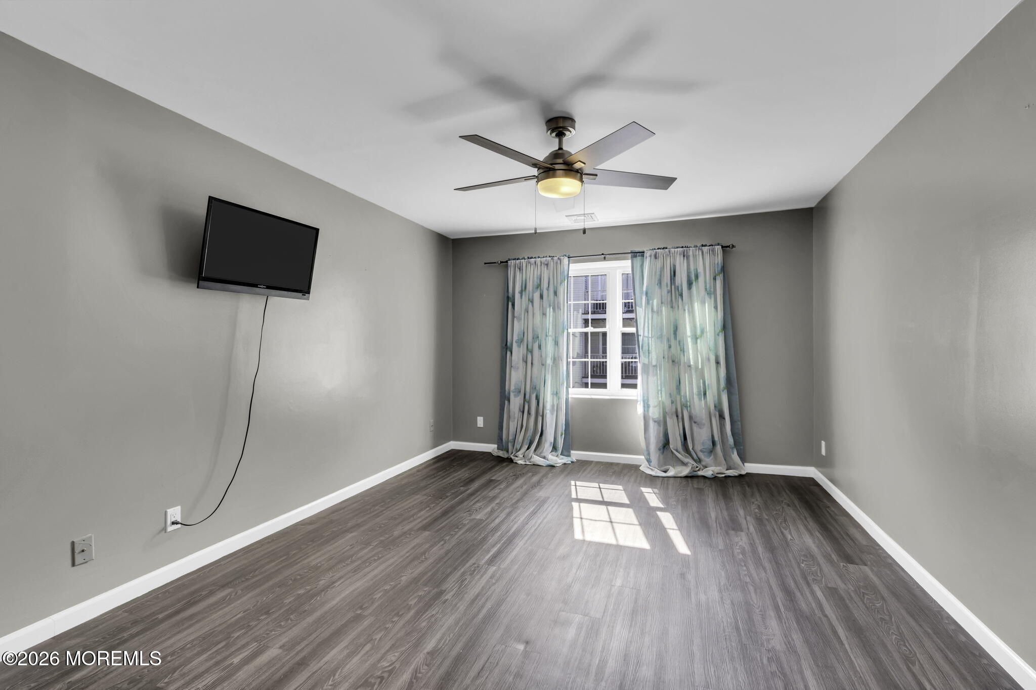 231 Atlantic Street, Unit 55 Keyport, NJ 07735 - Photo 12 of 31 an empty room with wooden floor and windows