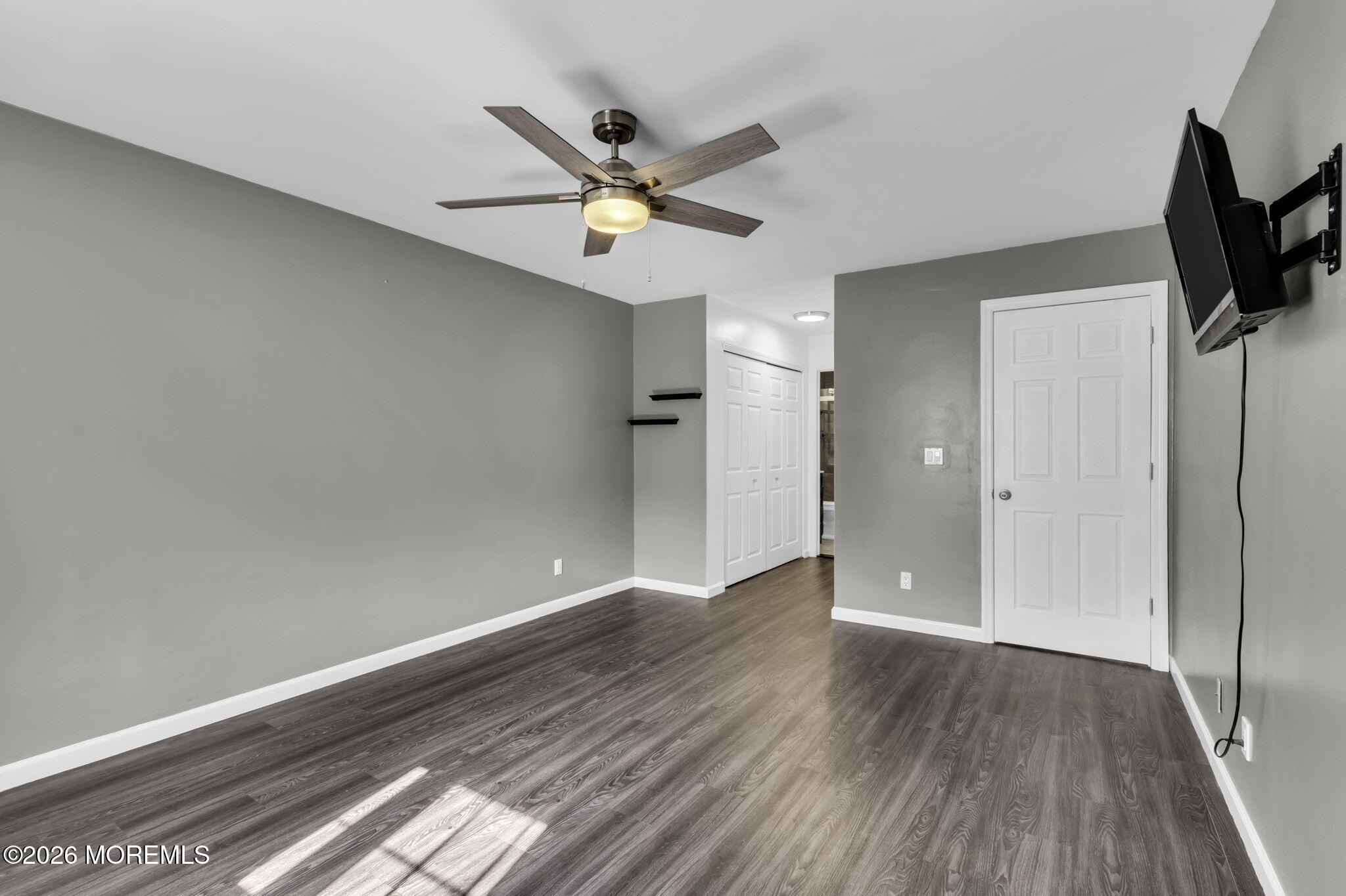 231 Atlantic Street, Unit 55 Keyport, NJ 07735 - Photo 14 of 31 a view of empty room with wooden floor and fan
