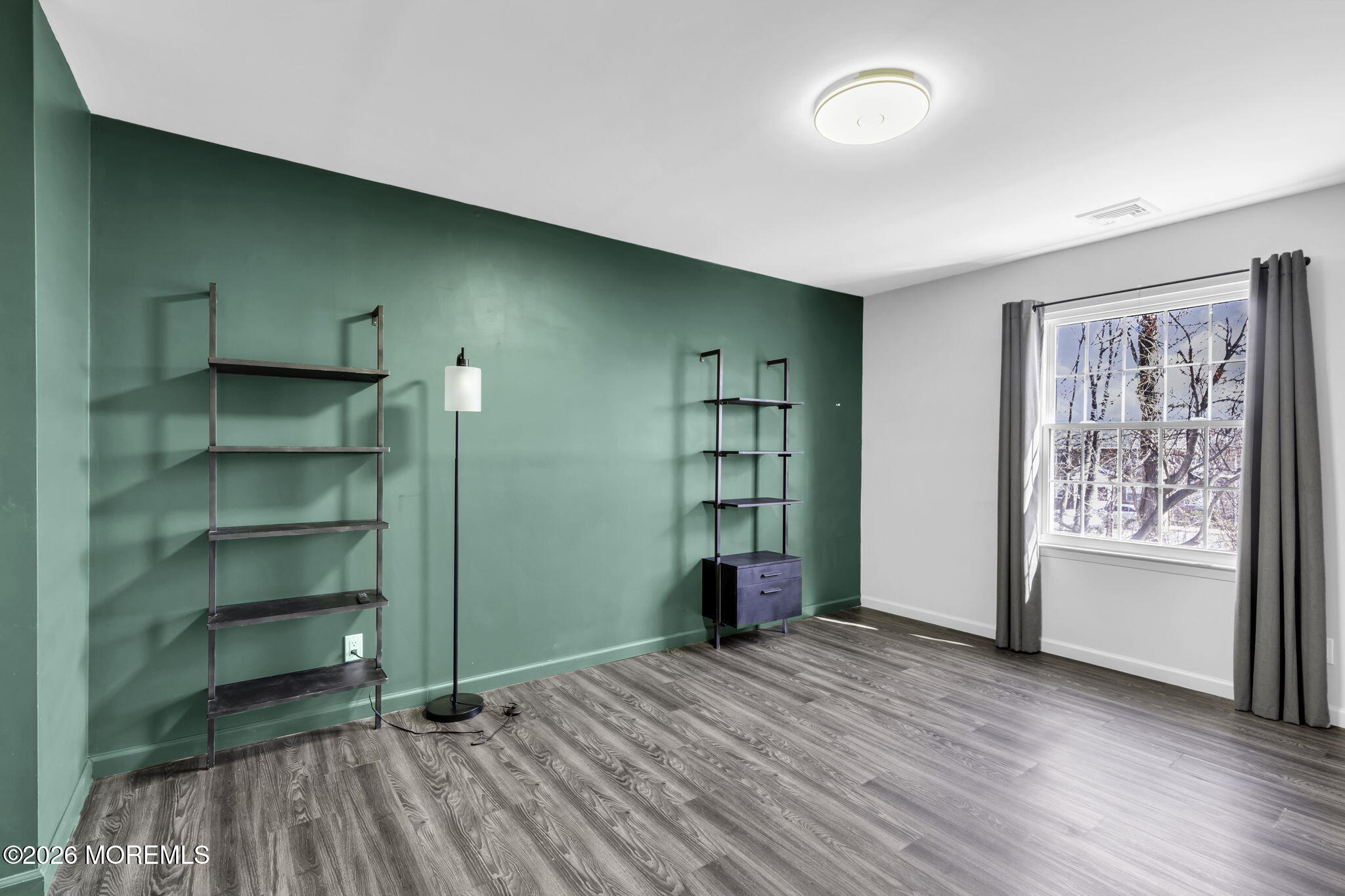 231 Atlantic Street, Unit 55 Keyport, NJ 07735 - Photo 19 of 31 a view of an empty room with a window and wooden floor