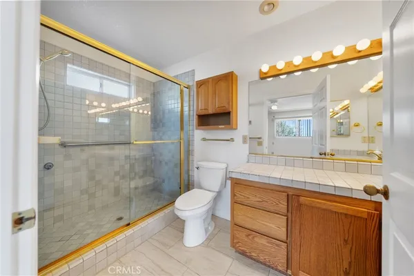a spacious bathroom with a granite countertop sink mirror and bathtub