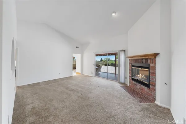 a view of an empty room with a window and a fireplace