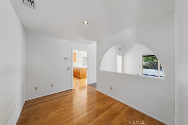 a view of empty room with wooden floor