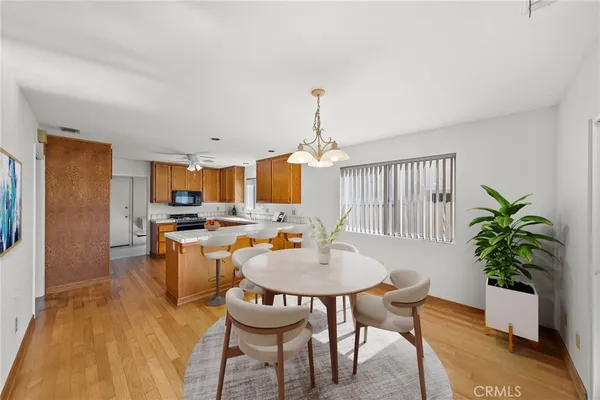 a dining room with furniture potted plants and wooden floor