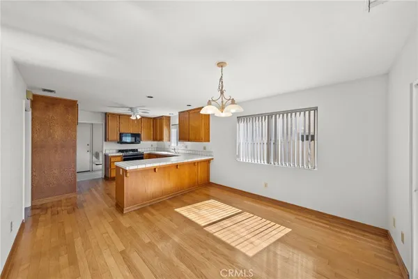 a kitchen with stainless steel appliances granite countertop a stove a sink dishwasher and a refrigerator with wooden floor