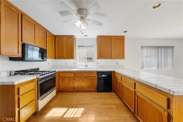a large kitchen with stainless steel appliances granite countertop a stove sink and cabinets