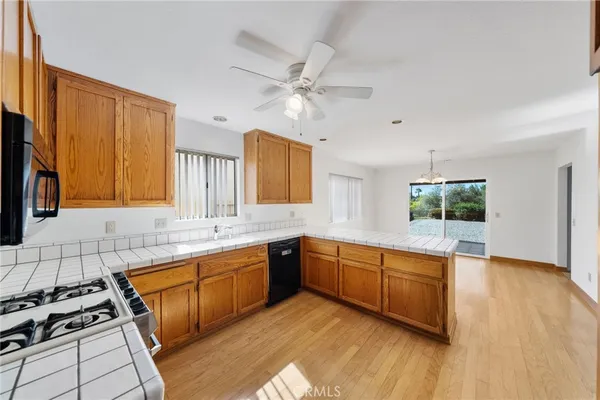 a large kitchen with stainless steel appliances granite countertop a stove a sink dishwasher and a oven with white cabinets