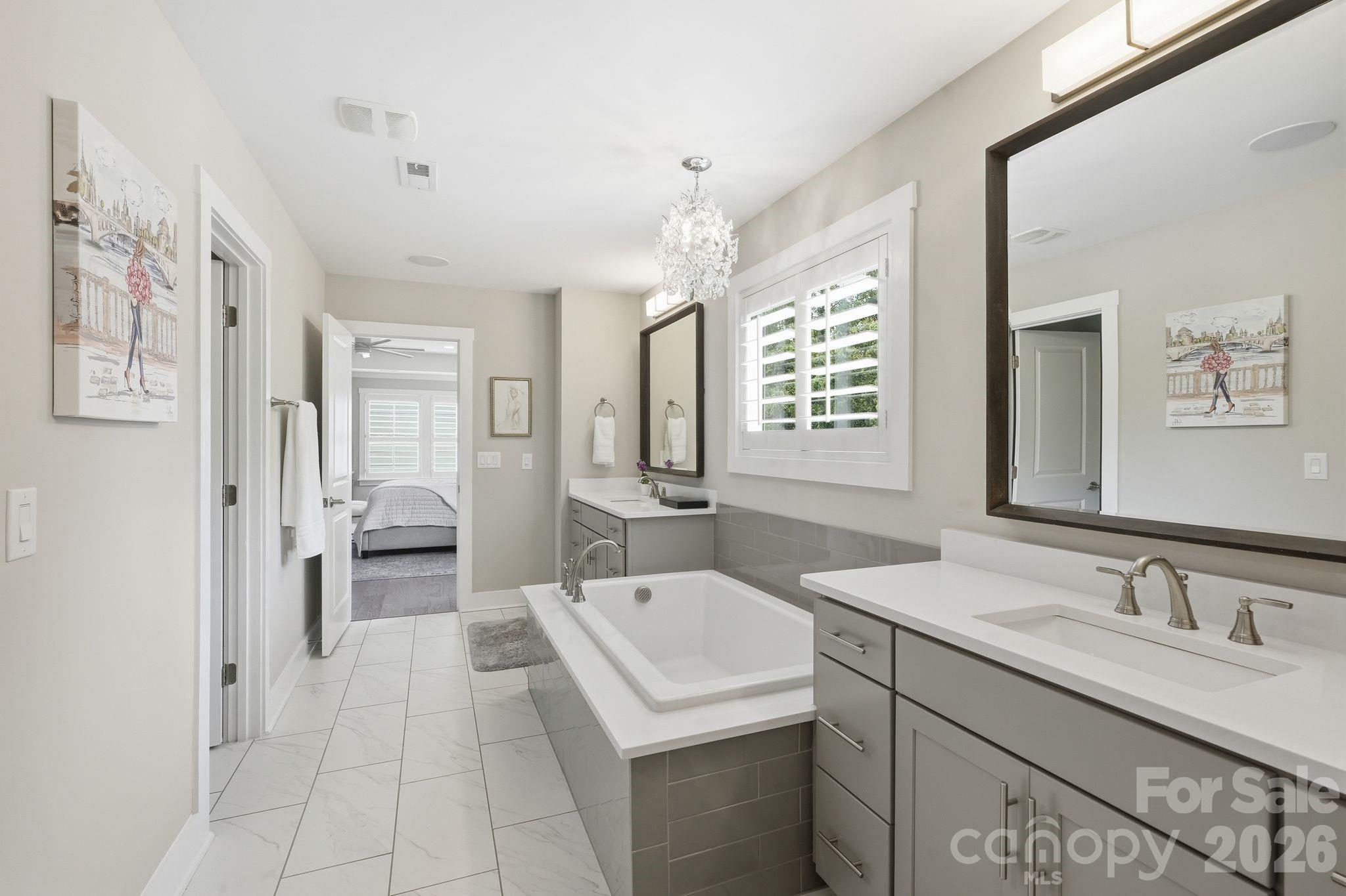 1086 Weir Court Fort Mill, SC 29708 - Photo 22 of 40 a spacious bathroom with a granite countertop sink a mirror and a bathtub