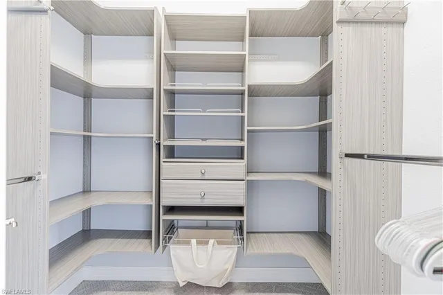 a view of walk in closet with empty racks