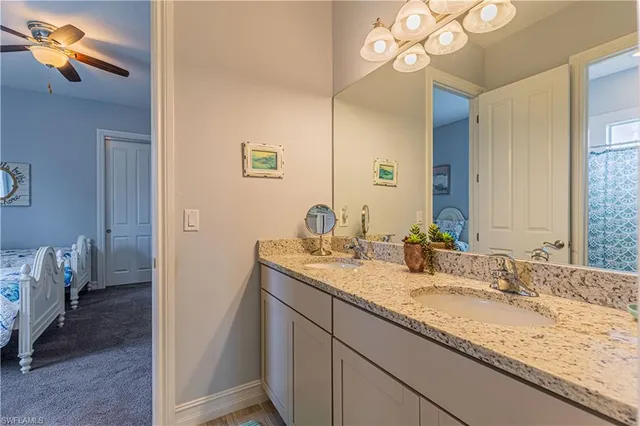 a bathroom with a granite countertop sink a toilet and a mirror