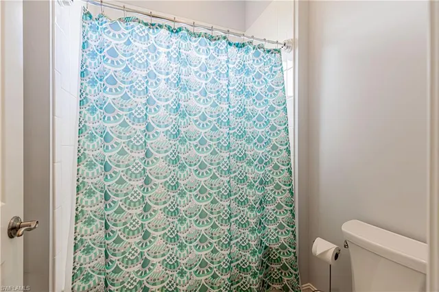 a bathroom with a toilet and a shower curtain