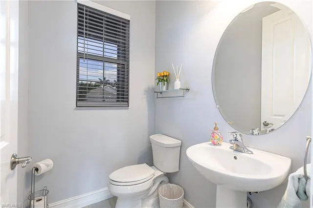 a bathroom with a sink toilet and a mirror