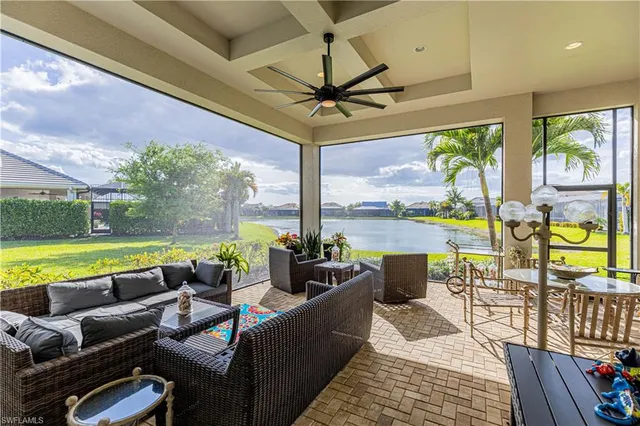 a living room with patio furniture and a floor to ceiling window