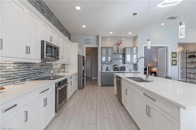 a large kitchen with stainless steel appliances lots of counter space and a sink