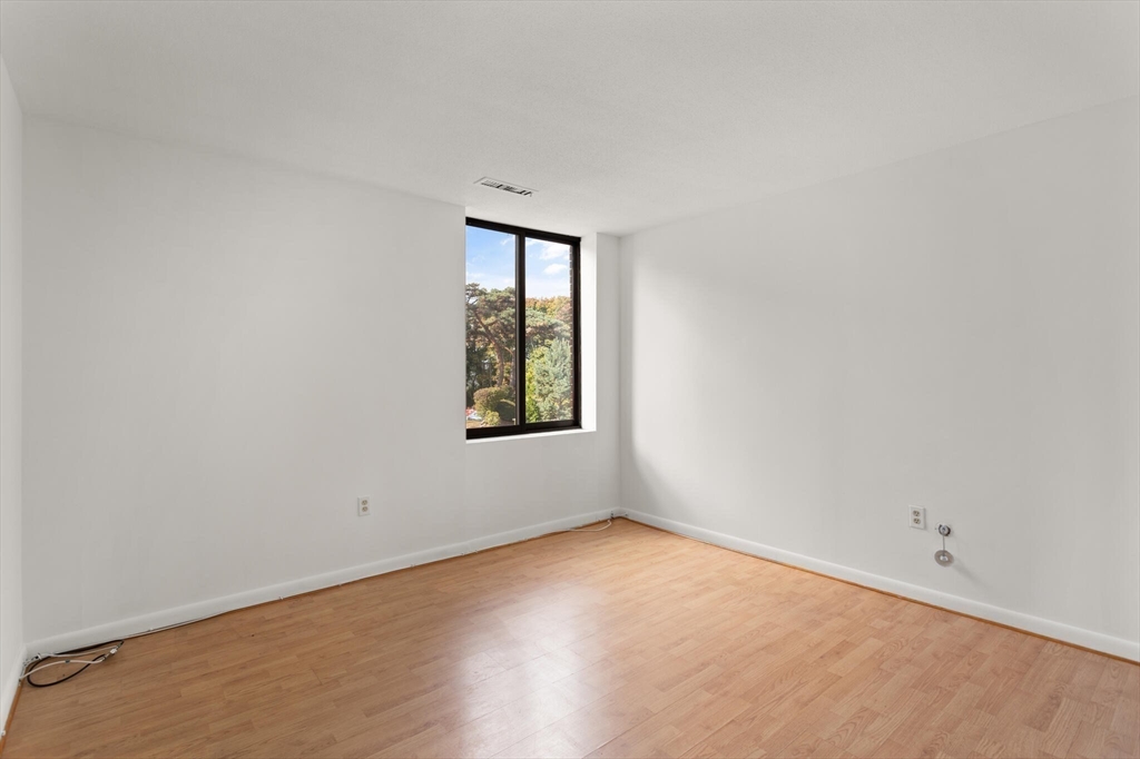 1008 Paradise Road, Unit 2R Swampscott, MA 01907 - Photo 14 of 18 an empty room with wooden floor and windows