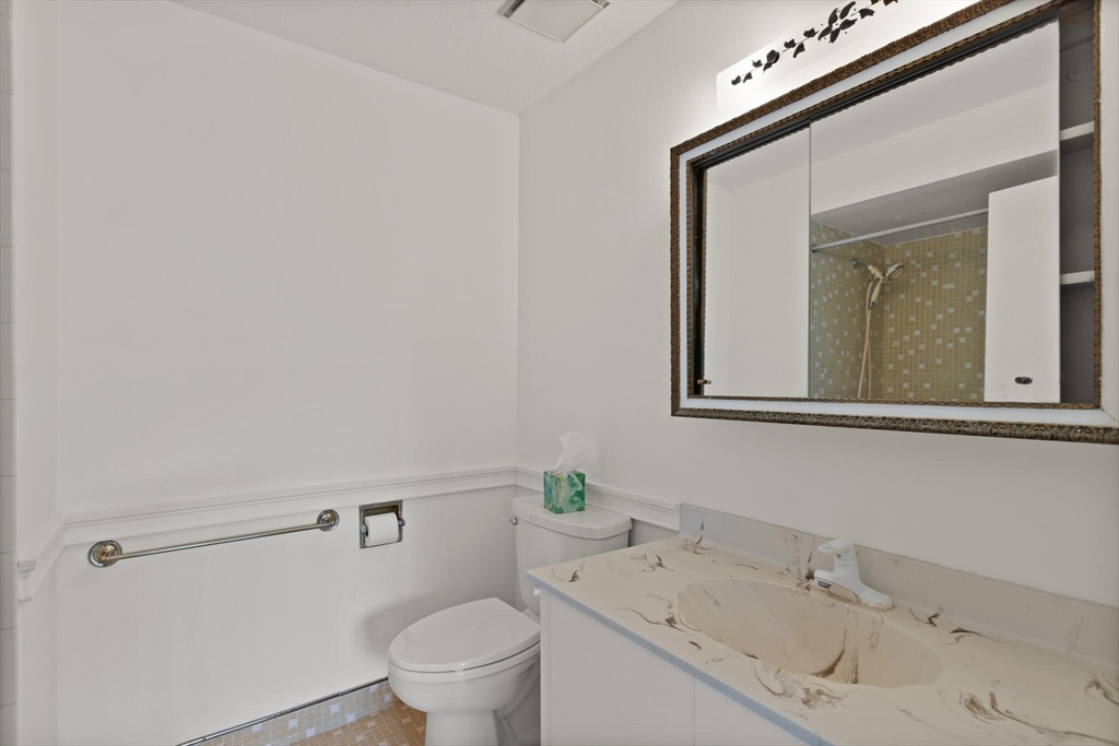 1008 Paradise Road, Unit 2R Swampscott, MA 01907 - Photo 16 of 18 a bathroom with a sink a toilet and mirror