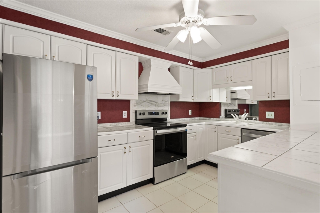 1008 Paradise Road, Unit 2R Swampscott, MA 01907 - Photo 5 of 18 a kitchen with white cabinets and white appliances