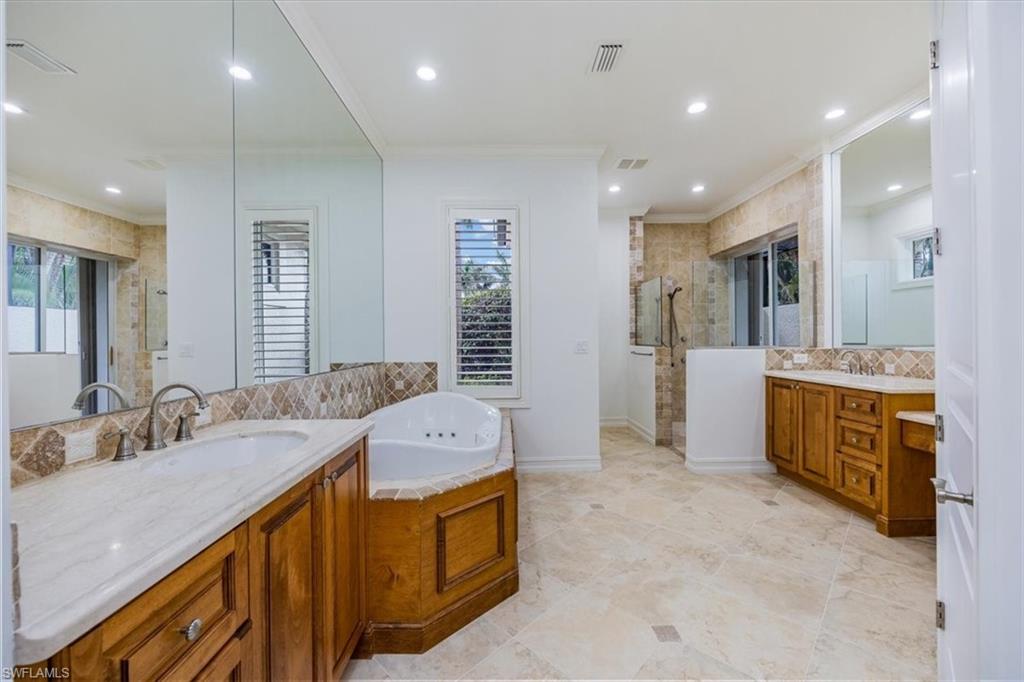 3110 Crayton Road Naples, FL 34103 - Photo 16 of 38 Primary bathroom with tile floor, dual vanities, W/C (not shown), jetted bathtub and shower.