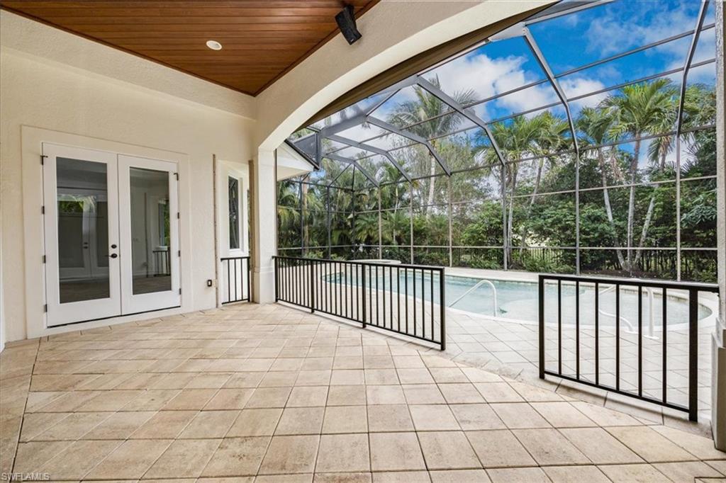 3110 Crayton Road Naples, FL 34103 - Photo 30 of 38 Covered area with wood ceiling, pavers and french doors with views of the pool/spa/enclosed lanai.