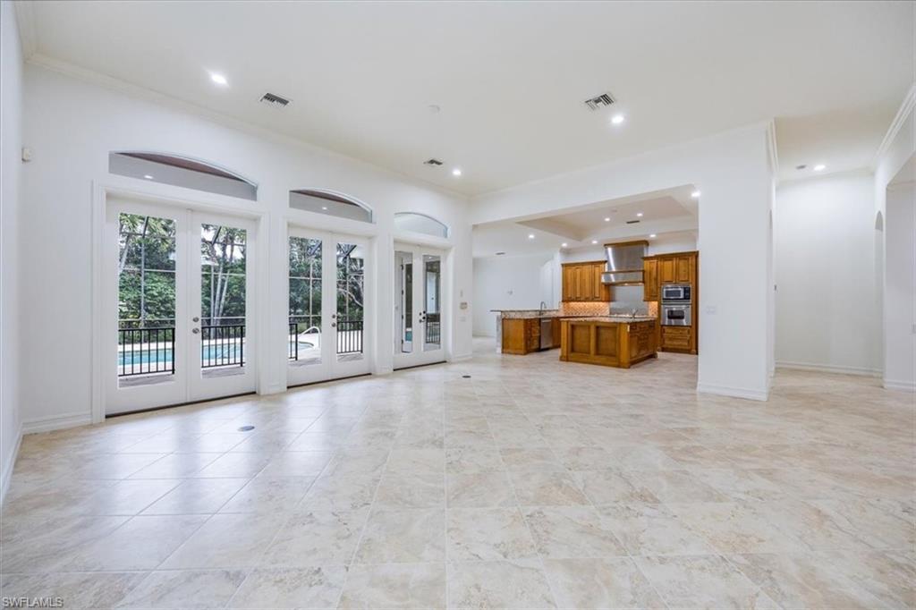 3110 Crayton Road Naples, FL 34103 - Photo 3 of 38 Great room with access to the kitchen and the pool/spa/lanai thru french doors.