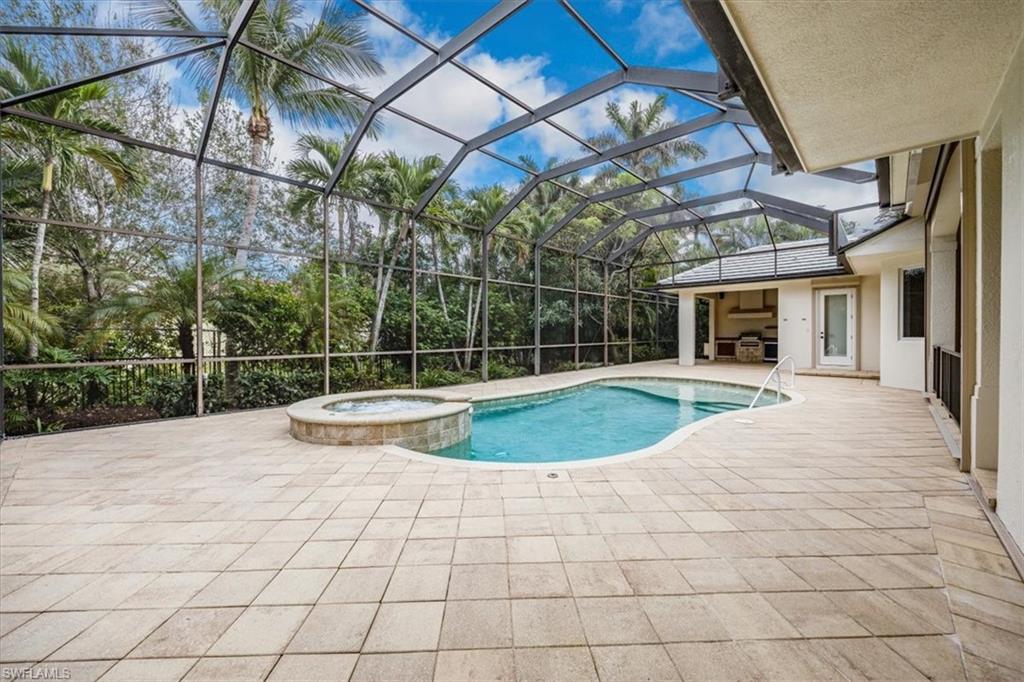 3110 Crayton Road Naples, FL 34103 - Photo 32 of 38 Enclosed lanai with pool, spa, covered area (to the far right) and outdoor kitchen.