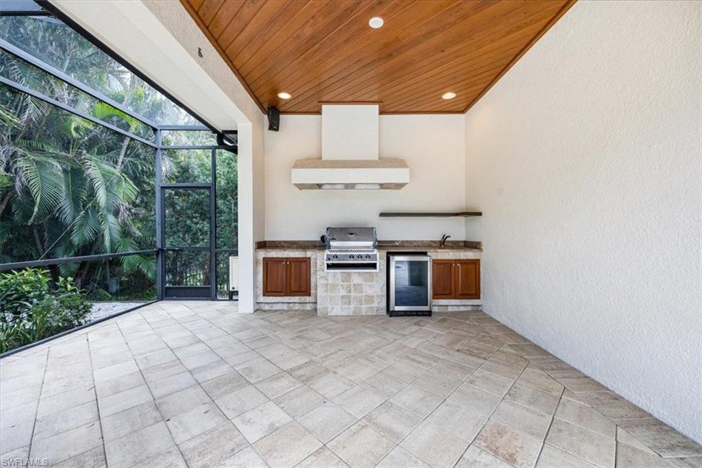 3110 Crayton Road Naples, FL 34103 - Photo 35 of 38 Outdoor kitchen with grill & vent hood, beverage cooler, sink and storage.