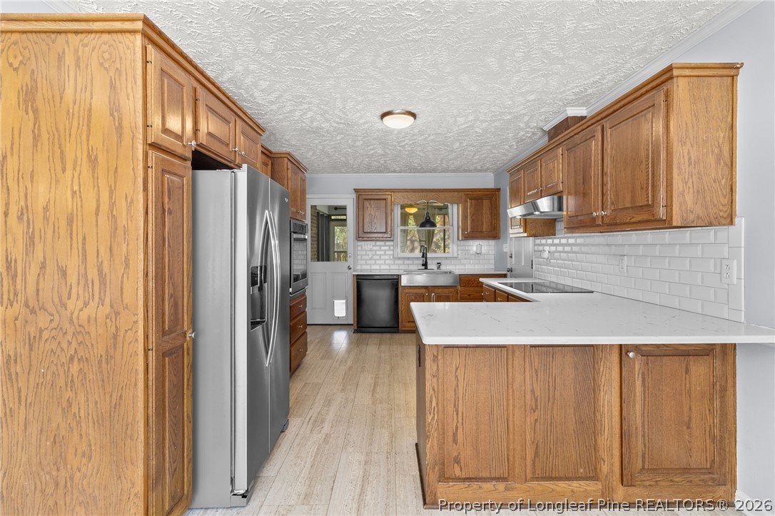 7756 Dragonhead Road Fayetteville, NC 28311 - Photo 12 of 42 a kitchen with kitchen island granite countertop wooden cabinets a sink and a refrigerator