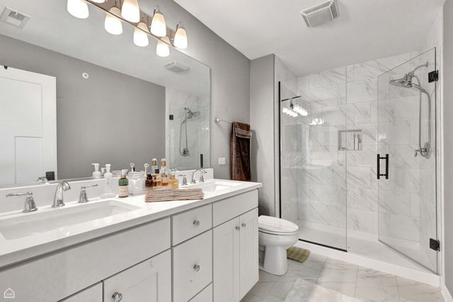 809 Lee Street Des Plaines, IL 60016 - Photo 13 of 18 a bathroom with a double vanity sink toilet and shower