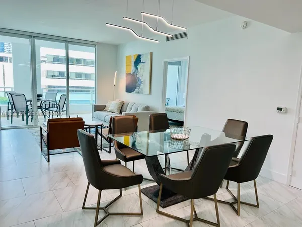 a view of a dining room with furniture and a large window