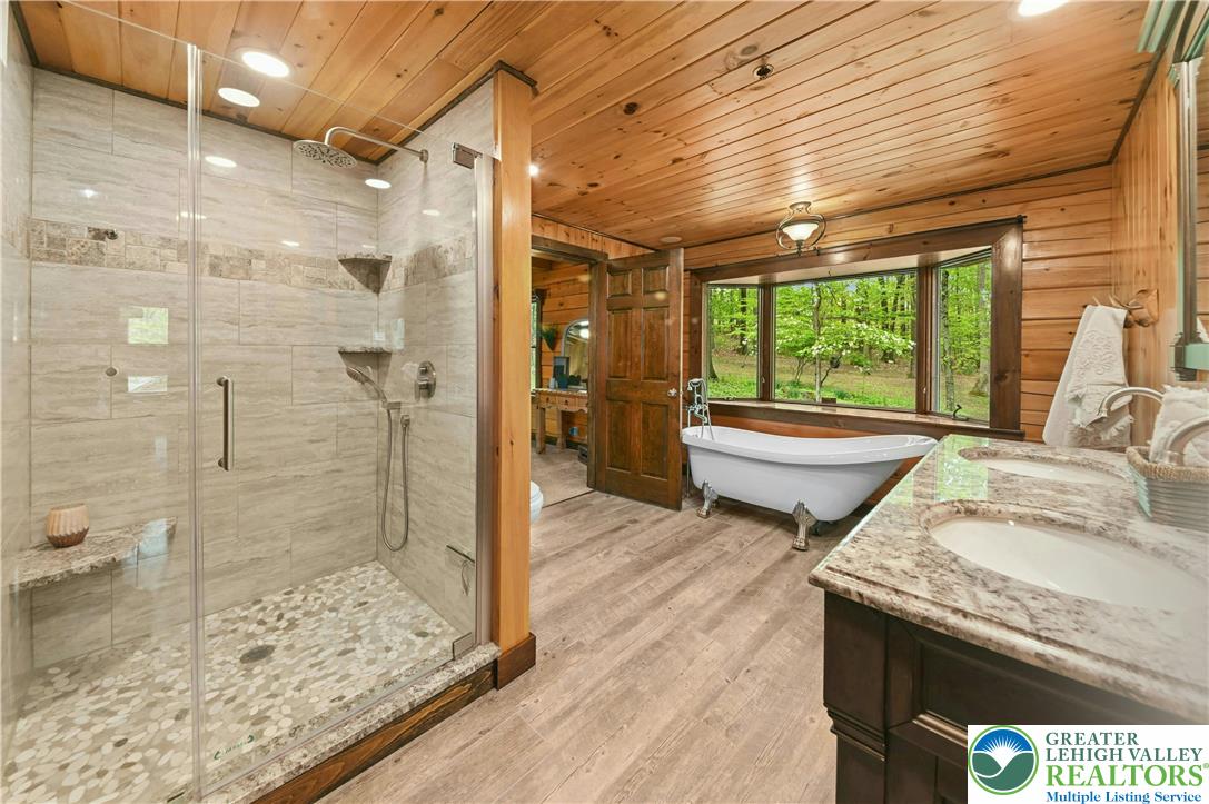 294 Nockamixon Road Kintnersville, PA 18930 - Photo 25 of 58 a bathroom with a granite countertop sink a toilet a mirror and shower