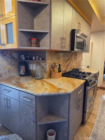a kitchen with stainless steel appliances granite countertop a sink a stove and a microwave